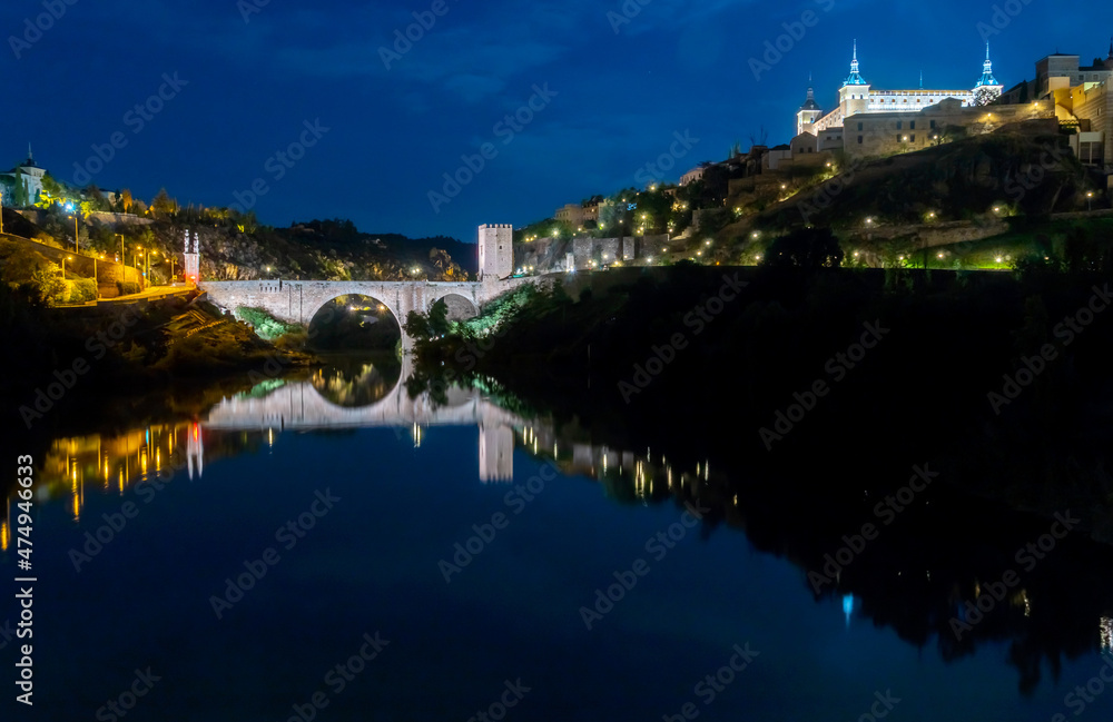 The Toledo Spain Alcantara Bridge Reflectd on the Tagus River at Night