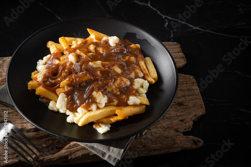 Delicious poutine with fresh cheese curd and gravy melted cheese into perfection on white background photo