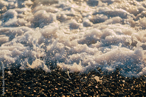 White wave splash on the pebble beach