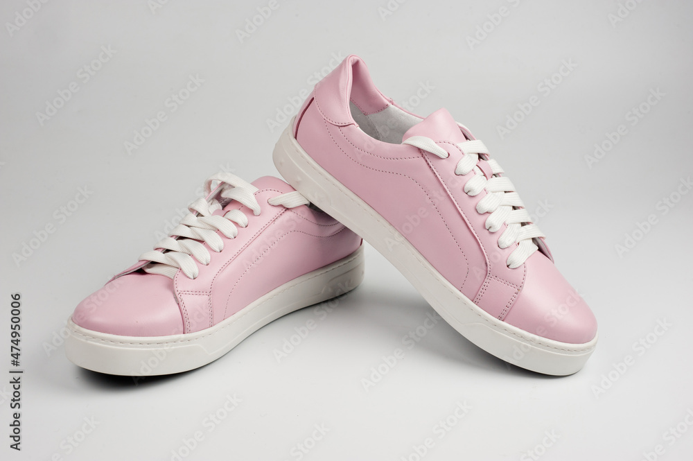Light pink faux leather shoes laced with laces. Close-up shot. Light pink faux leather shoes laced with laces. Close-up shot.