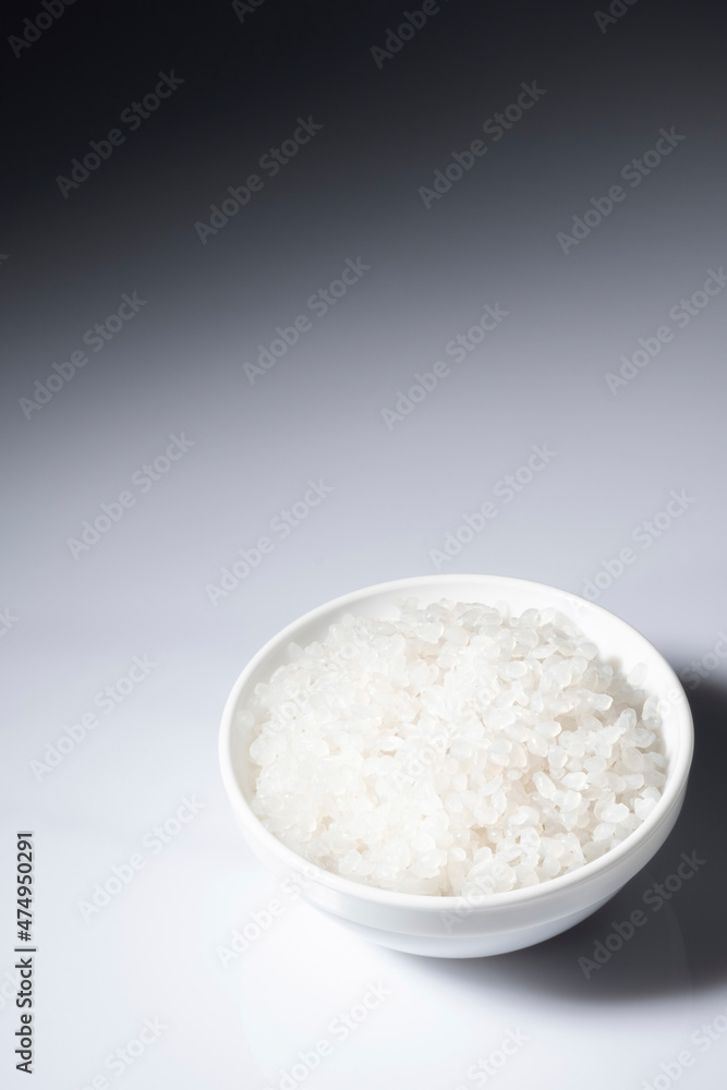 Shirataki rice or noodles in a bowl on white and black background. Konnyaku from konjac yam for wok. Healthy japanese diet. Gluten free and carbs free KETO food. Traditional oriental style. Close up Shirataki rice or noodles in a bowl on white and black background. Konnyaku from konjac yam for wok. Healthy japanese diet. Gluten free and carbs free KETO food. Traditional oriental style. Close up