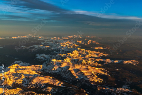 Aerial view of the Rocky Mountains covered by snow on sunset