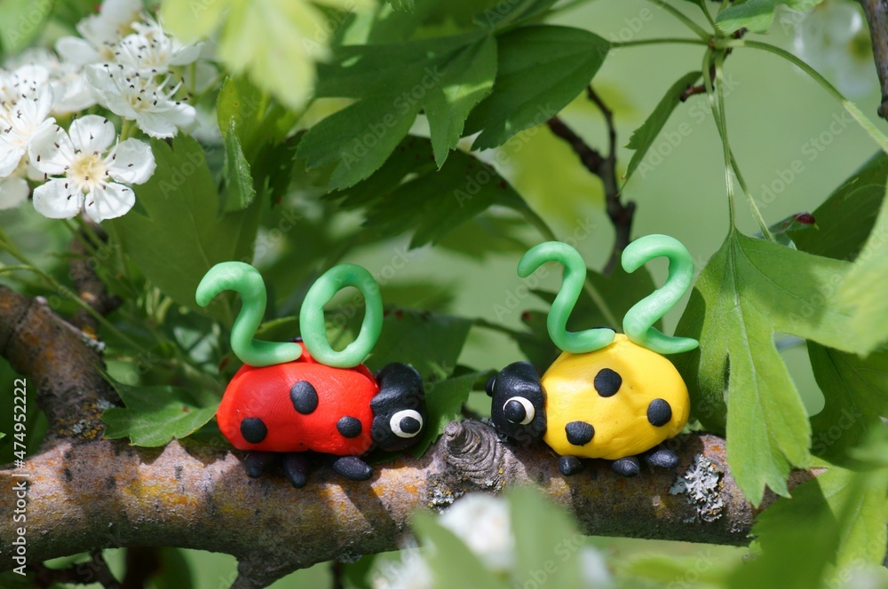 Figurines of two ladybirds made of plasticine. At the top is the calendar date 2022. Figurines of two ladybirds made of plasticine. At the top is the calendar date 2022.