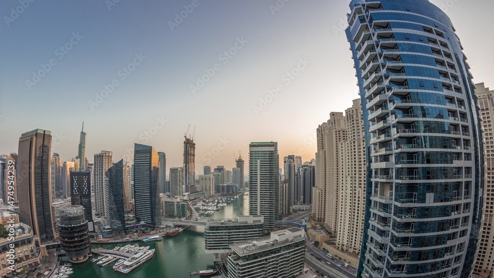 Obraz premium Aerial view to Dubai marina skyscrapers around canal with floating boats day to night timelapse