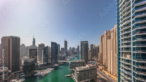 Aerial view to Dubai marina skyscrapers around canal with floating boats all day timelapse © neiezhmakov