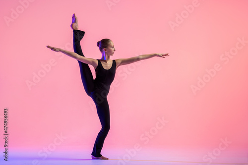 Fotografija Young teenager dancer dancing on a red studio background