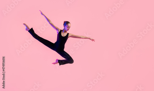 Young teenager dancer dancing on a red studio background. Ballet, dance, art, modernity, choreography concept © Maria Moroz