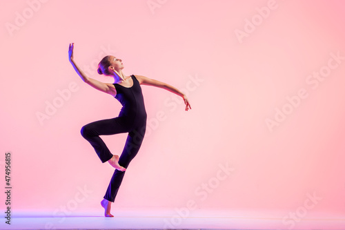 Fototapeta Young teenager dancer dancing on a red studio background