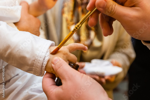 Fototapeta Orthodox christening of a baby, holding gold cross