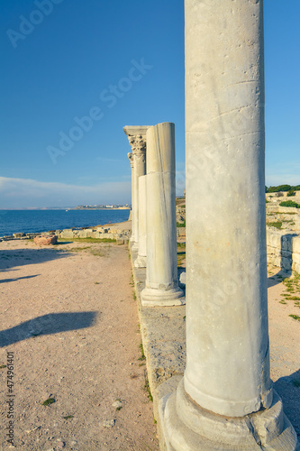 Columns of an ancient Greek temple against the background of the sea.