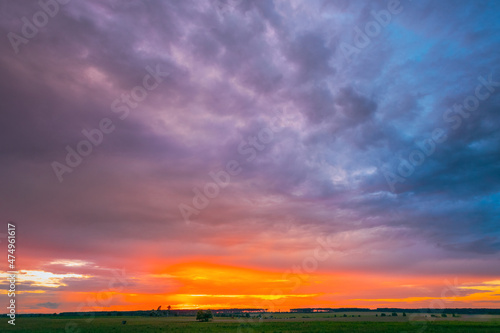 Spring Sunset Sky Above Countryside Rural Meadow Landscape. Sunny Spring Dramatic Sky. Skyline. Agricultural Landscape. Copy Space