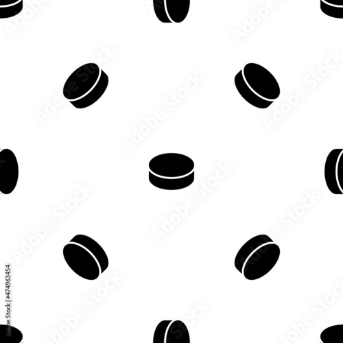 Seamless pattern of repeated black hockey pucks. Elements are evenly spaced and some are rotated. Vector illustration on white background