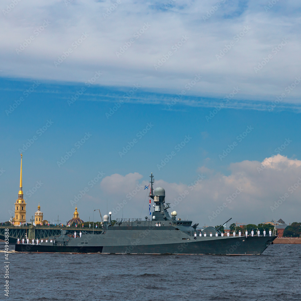 a modern warship passes along the Neva against the background of the bridge and the Peter and Paul Fortress