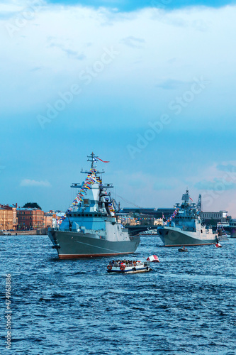 Modern warships. Tourists from pleasure ships and the embankment look at the warships on the Neva. Before the naval parade in St. Petersburg  Russia