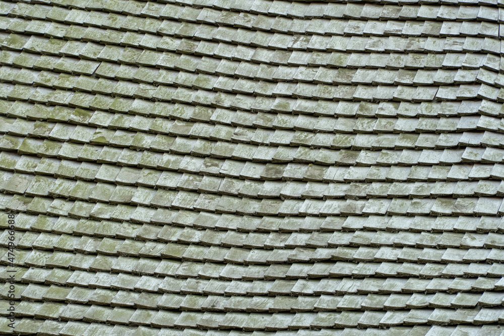 Shingle wooden tile facade background. Texture of old weathered wooden tiled roof or the floor of old wooden boards. Eco background. Environmental conservation, eco-friendly house concept Shingle wooden tile facade background. Texture of old weathered wooden tiled roof or the floor of old wooden boards. Eco background. Environmental conservation, eco-friendly house concept