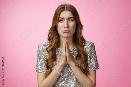 Please beg you. Clingy silly miserable supplicating young cute female curly-haired praying whining about cry press palms together asking please do favor need help, standing pink background