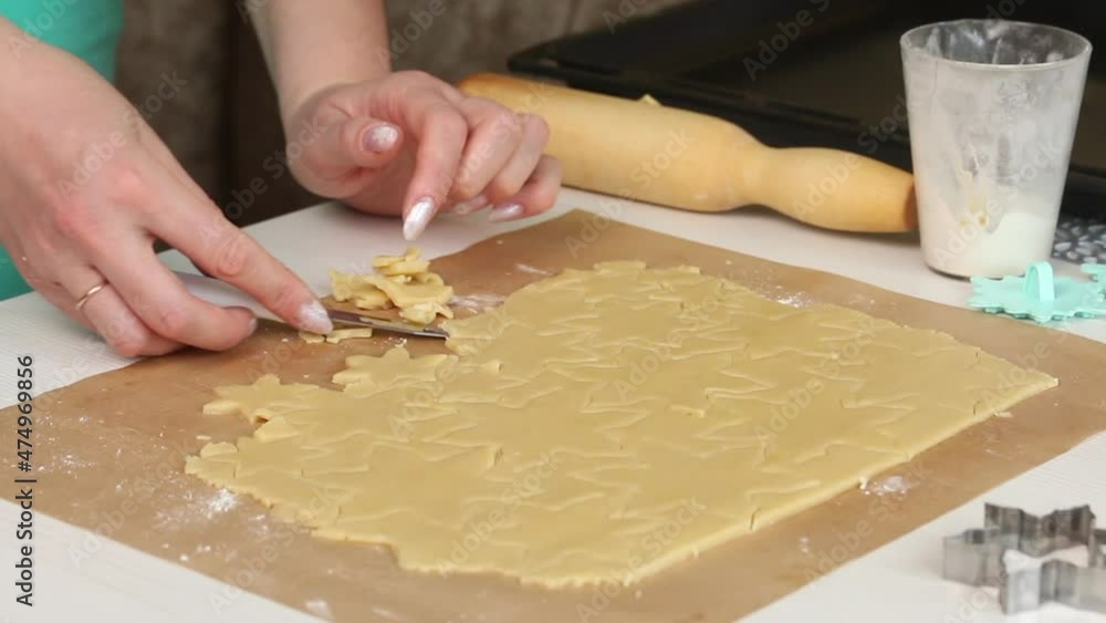 Woman works with snowflake cookie dough. Cooking marshmallow sandwiches. Close-up shot.