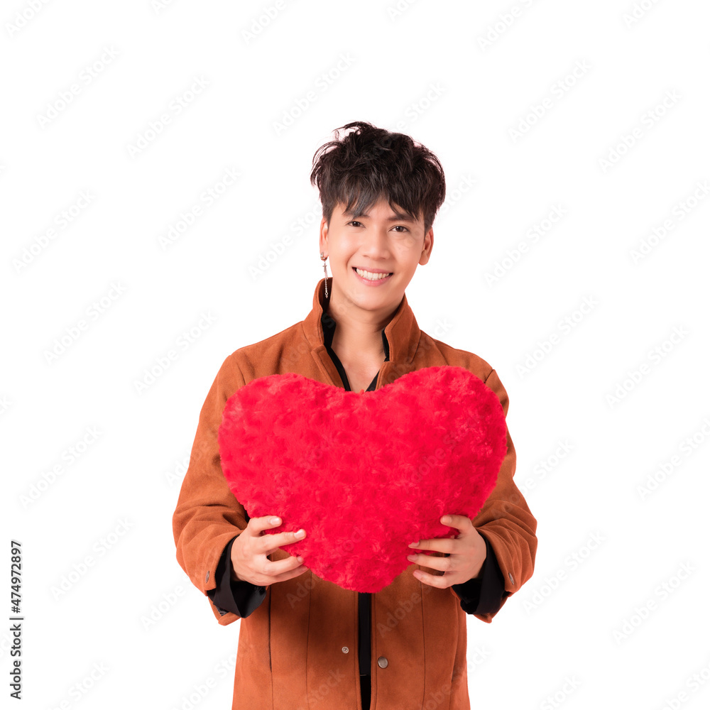 Portrait of happy handsome Asian young man in fashionable clothes standing smiling and holding red heart shape pillow in studio isolated on white background with clipping path. Portrait of happy handsome Asian young man in fashionable clothes standing smiling and holding red heart shape pillow in studio isolated on white background with clipping path.