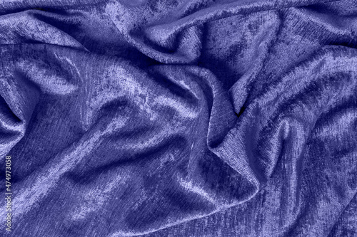Abstract background on velvet fabric colored of the year 2022 Very Peri. Top view. Texture of velvet purple drapery.