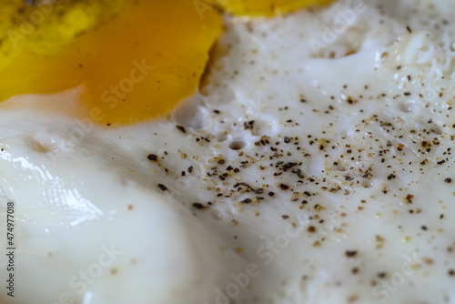 closeup of a fried egg cooked with salt and pepper