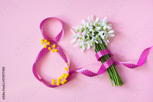 Background card for Women's day march 8, number eight from a pink ribbon and a bouquet of flowers snowdrops, mimosa. © tachinskamarina