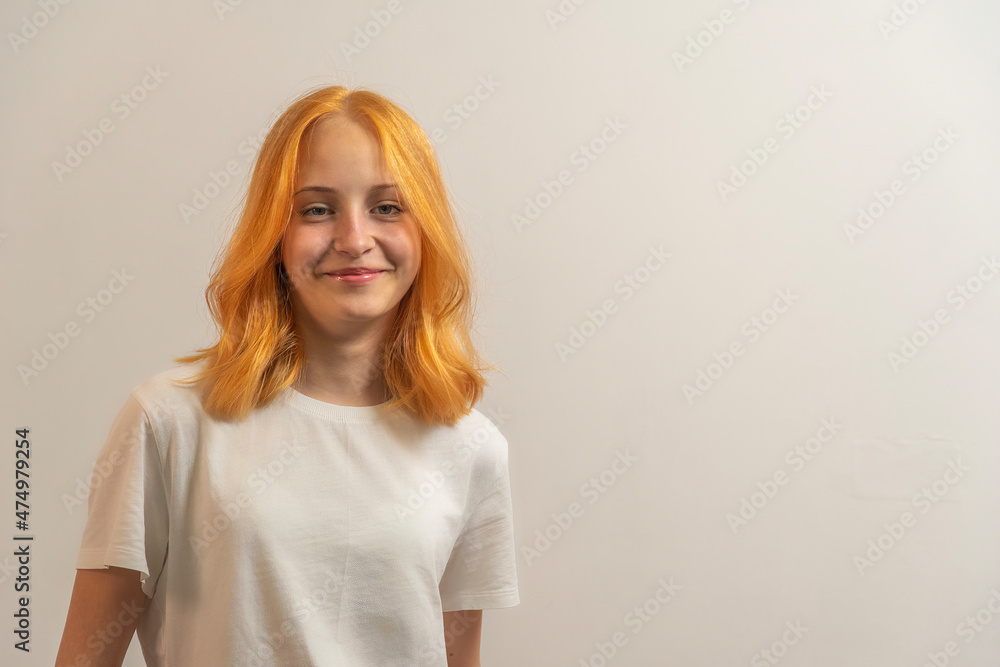portrait of a teenage girl with red hair in a white T-shirt on a light background portrait of a teenage girl with red hair in a white T-shirt on a light background