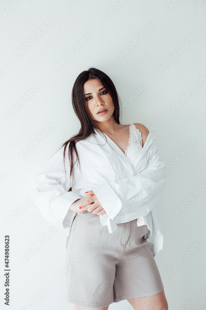portrait of a beautiful fashionable brunette woman in a white shirt portrait of a beautiful fashionable brunette woman in a white shirt
