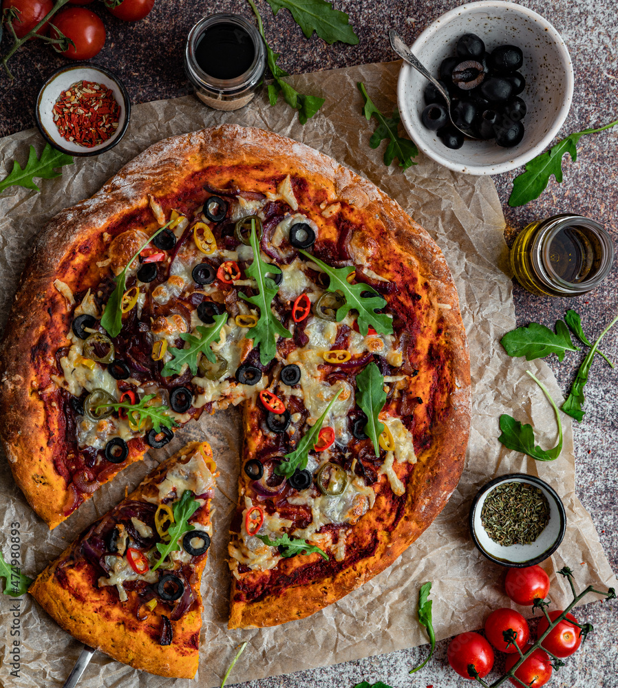 Domowa wegetariańska pizza na dyniowym spodzie, pizza z serem, mozarellą, oliwkami, ostrą papryczką i rukolą, pyszne danie, kuchnia włoska, restauracja, oliwa - obrazy, fototapety, plakaty 