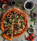 Domowa wegetariańska pizza na dyniowym spodzie, pizza z serem, mozarellą, oliwkami, ostrą papryczką i rukolą, pyszne danie, kuchnia włoska, restauracja, oliwa