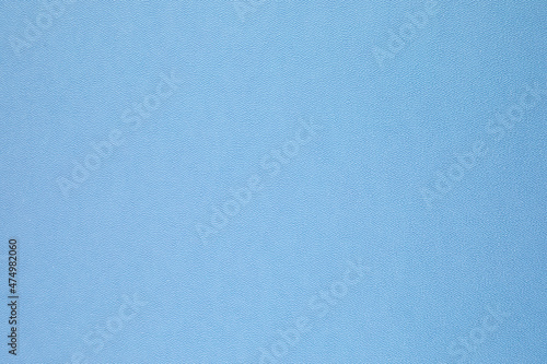 Smooth flat vintage paper bag pale texture in light blue color on table background.