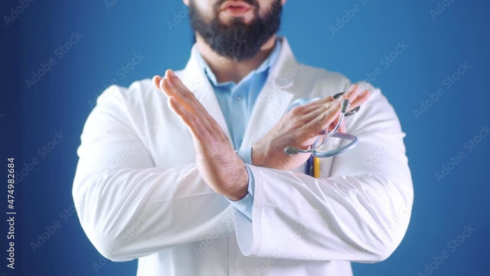 Doctor stops making prohibition signs. Doctor holding crossed hands in gloves Doctor stops making prohibition signs. Doctor holding crossed hands in gloves