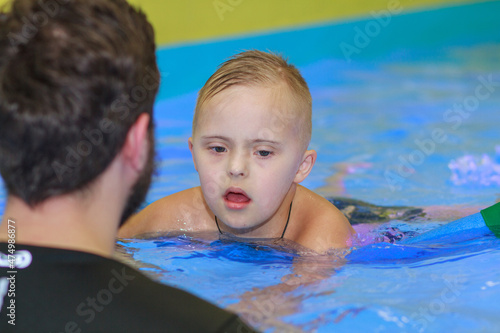 Принти на полотні A boy with Down syndrome learns to swim in the pool, rehabilitation of disabled children, genetic anomaly, psychiatric congenital disease