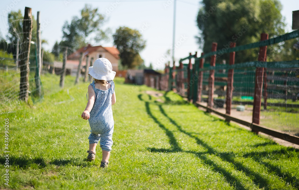 Little baby girl walking happy on a farm