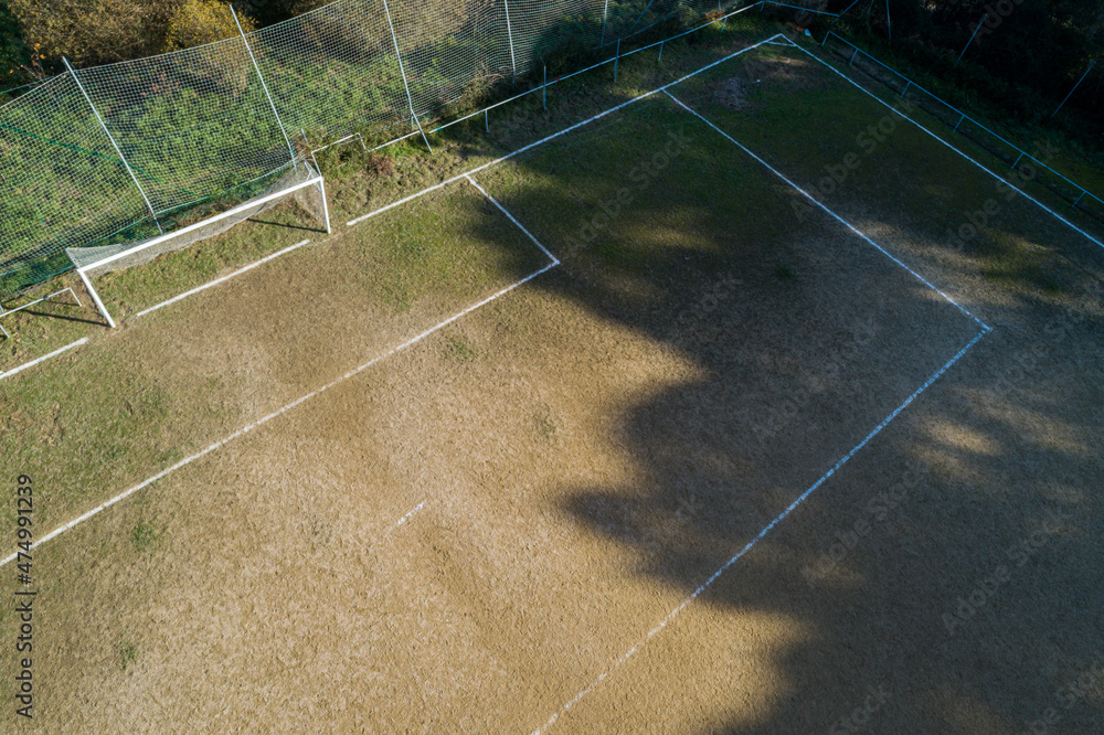 Drone view of the aerial and goalkeeping area of an amateur football field.