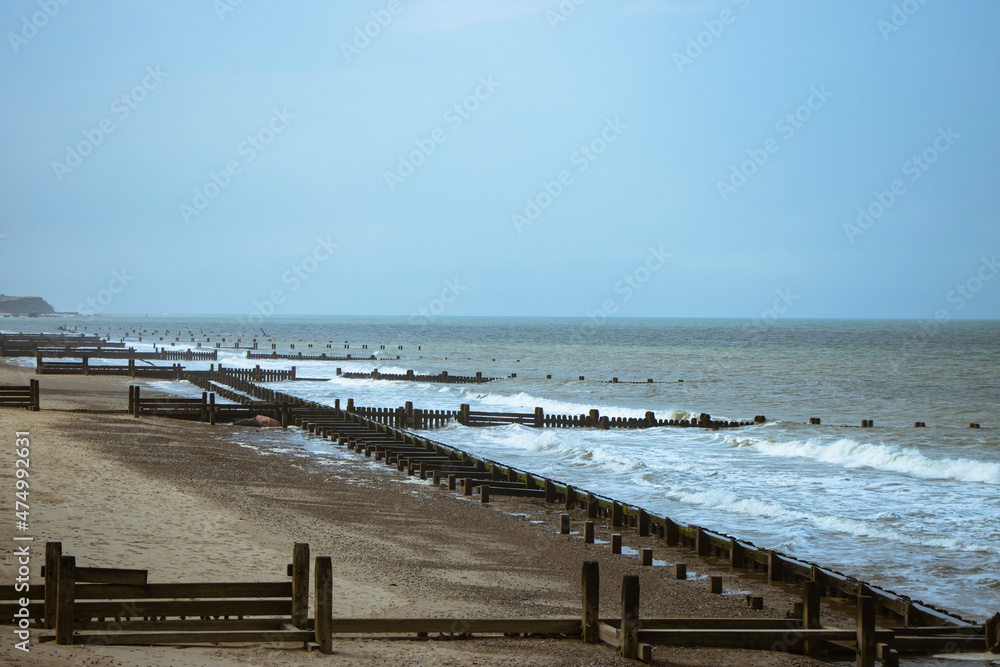 Beach and sea with wooden piers in Norwich, Norfolk, UK