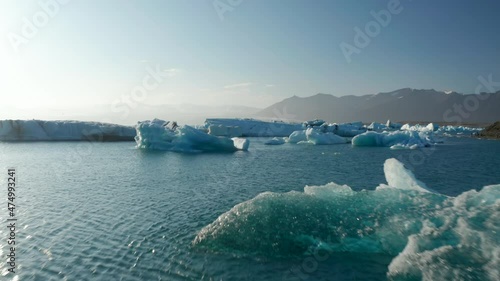 Scenic drone view glacier lagoon in Jokulsarlon lake, Iceland, with icebergs floating on water. Birds eye view of ice blocks drifting in Vatnajokull lagoon over Breidamerkurjokull glacier tongue photo