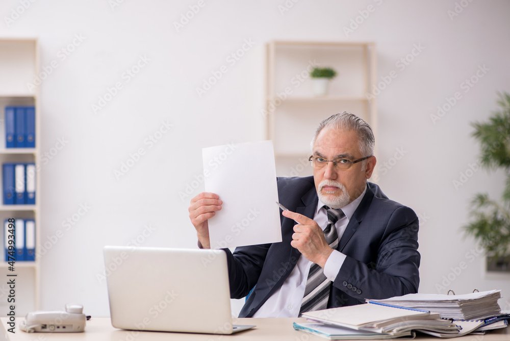 Old male employee working in the office Old male employee working in the office