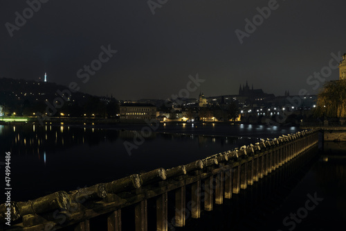 Prague at night near Vltava river and Charles Bridge, Prague Castle and Petřín Lookout Tower in the background. 