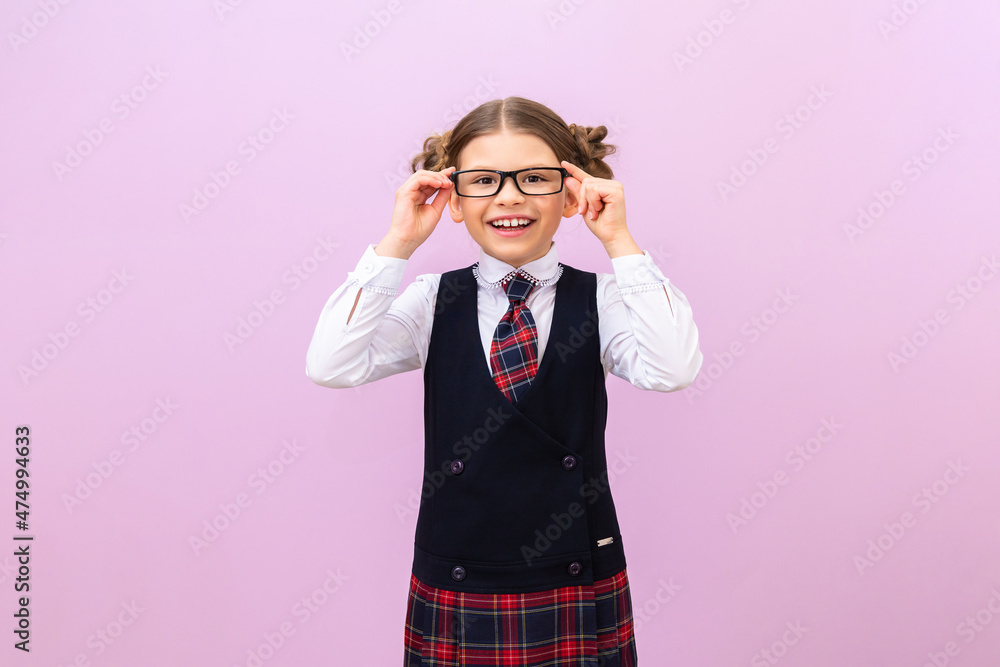 A schoolgirl in a school uniform and glasses on an isolated background. A student on a purple background.