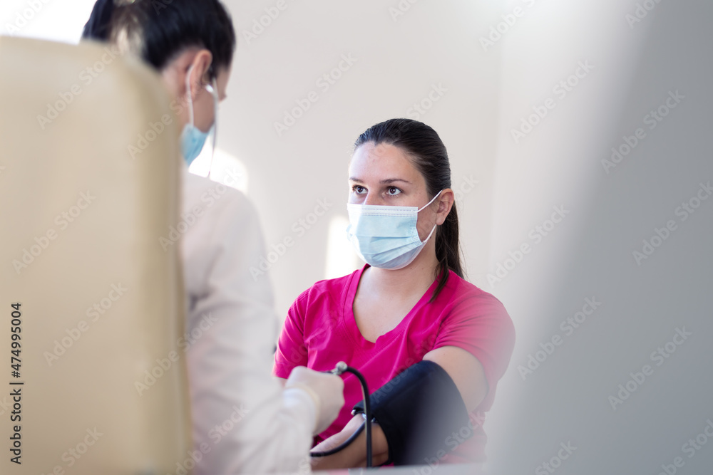 Female medicine doctor measuring blood pressure to patient