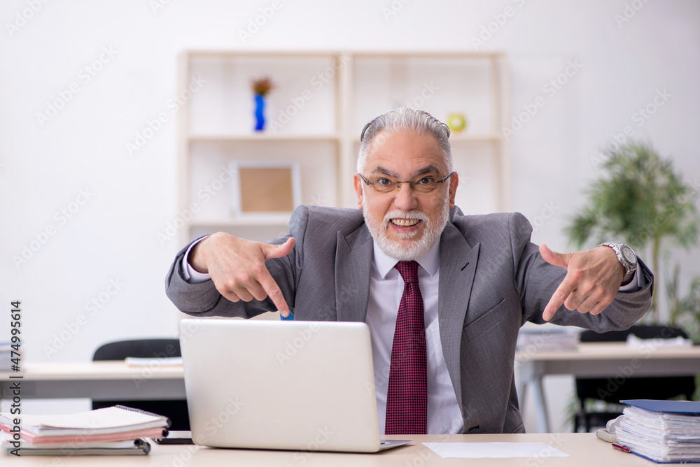Old male employee working in the office Old male employee working in the office