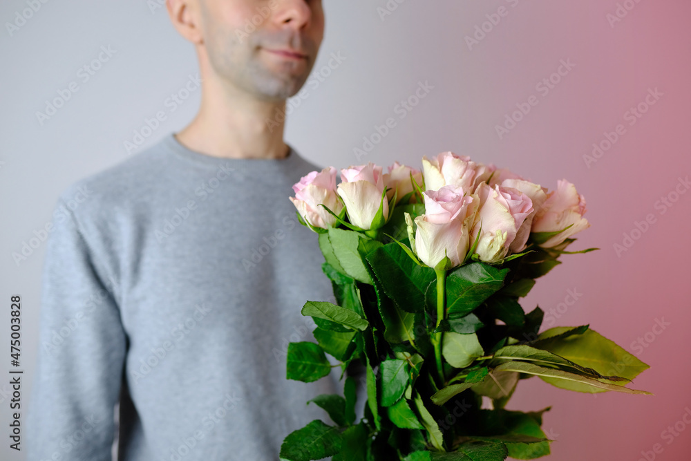 close-up of bouquet of white, pink roses in hands of young man, brought flowers on date with girlfriend, gives to mom, concept of mother's, Valentine's day, birthday, declaration of love close-up of bouquet of white, pink roses in hands of young man, brought flowers on date with girlfriend, gives to mom, concept of mother's, Valentine's day, birthday, declaration of love