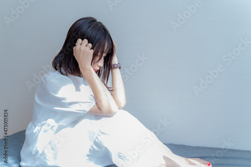 Fotografie 頭を抱えて座り込む女性