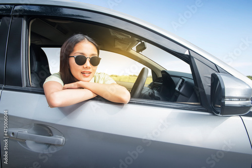Asian woman with sunglasses leaning