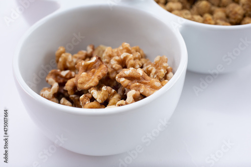 A closeup view of a party tray bowl full of walnuts. 