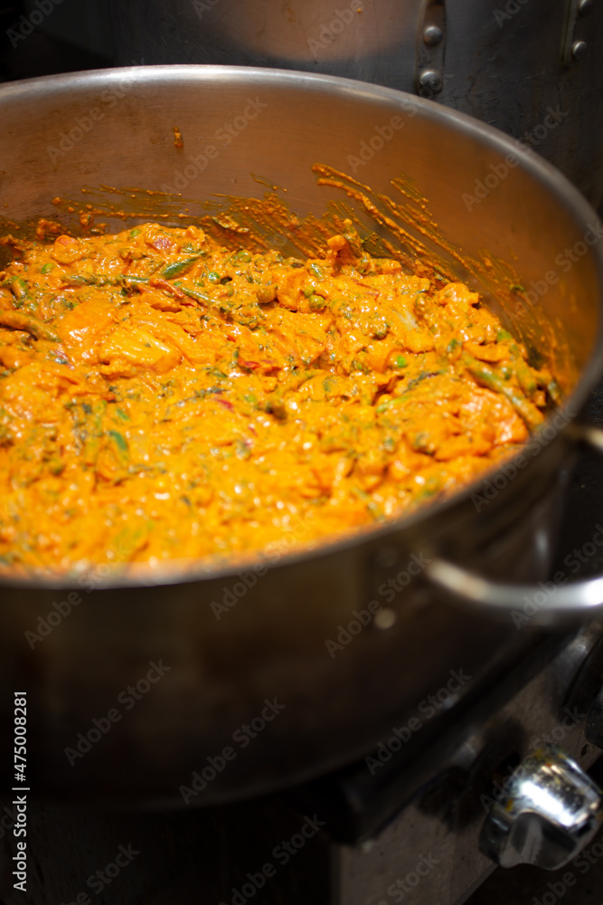 A view of a large stockpot filled with a type of Indian curry.