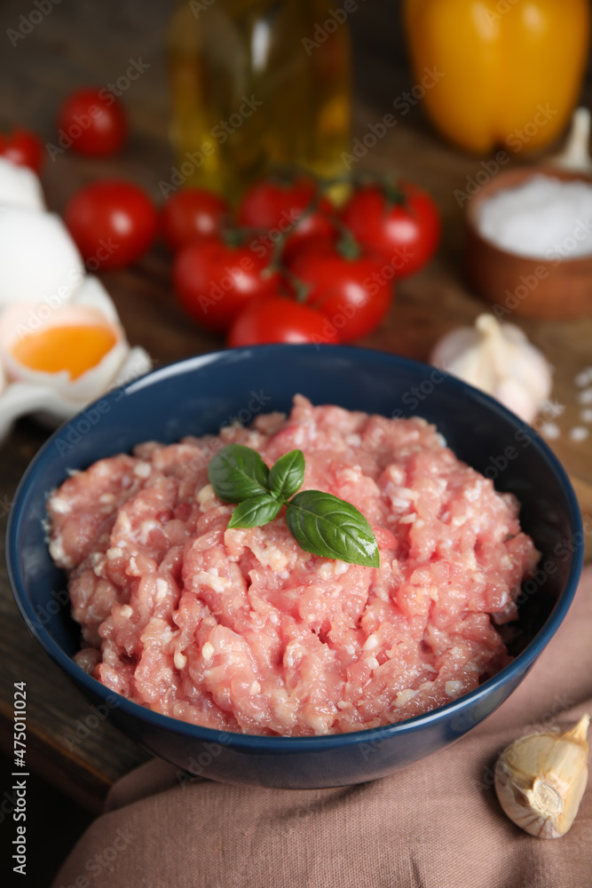 Raw chicken minced meat with basil and ingredients on table Raw chicken minced meat with basil and ingredients on table