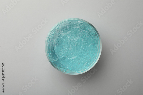 Jar of blue cosmetic gel on light background, top view
