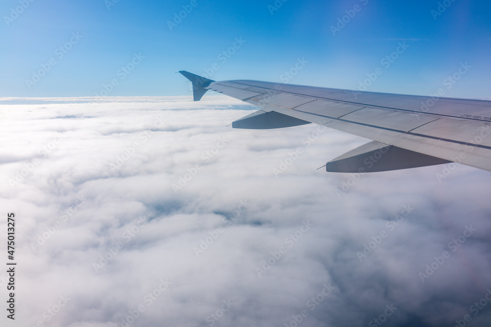 View from the airplane window at a beautiful cloudy sky and the airplane wing View from the airplane window at a beautiful cloudy sky and the airplane wing