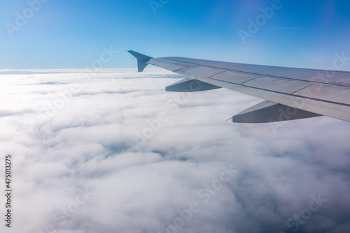 View from the airplane window at a beautiful cloudy sky and the airplane wing